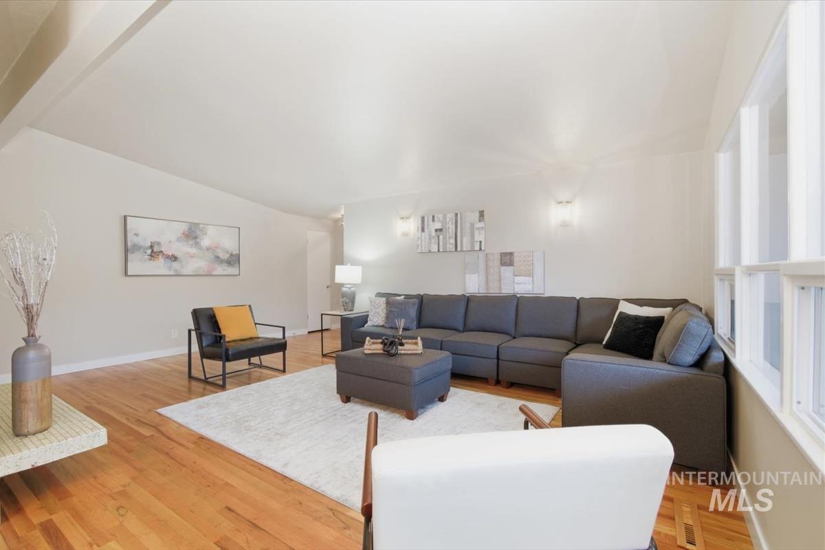 Living room featuring light wood-type flooring and vaulted ceiling