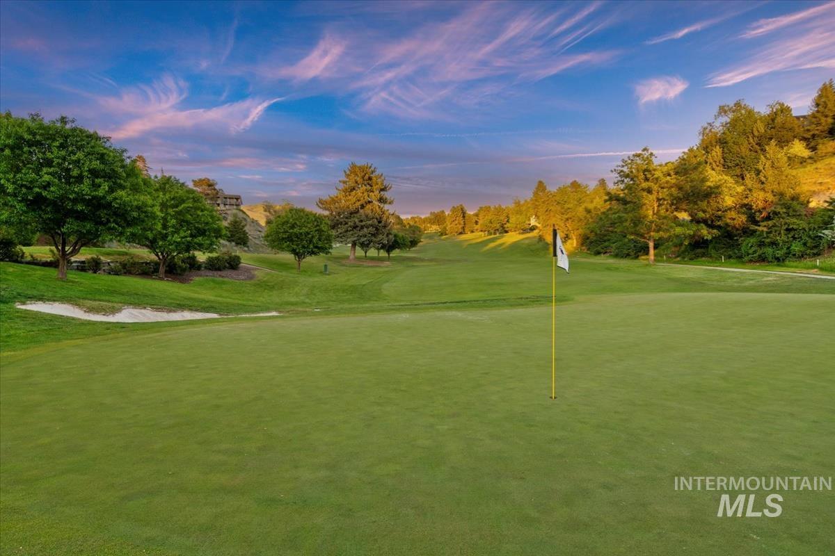 View of property's community with golf course view and view of wooded area