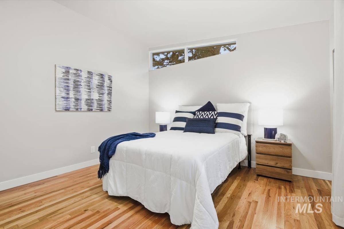 Bedroom featuring wood finished floors and baseboards