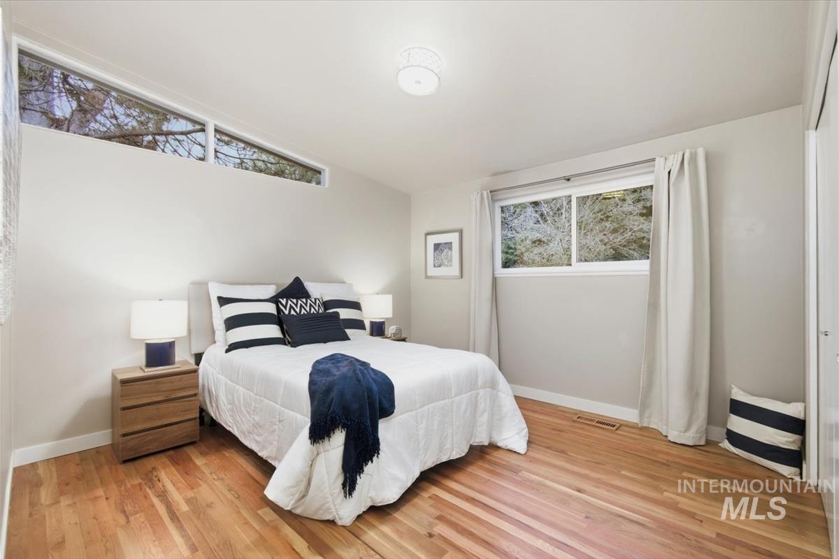 Bedroom featuring light wood finished floors and lofted ceiling