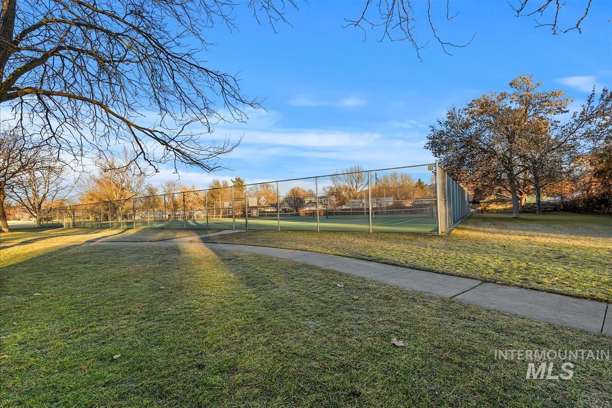 View of home's community with a tennis court