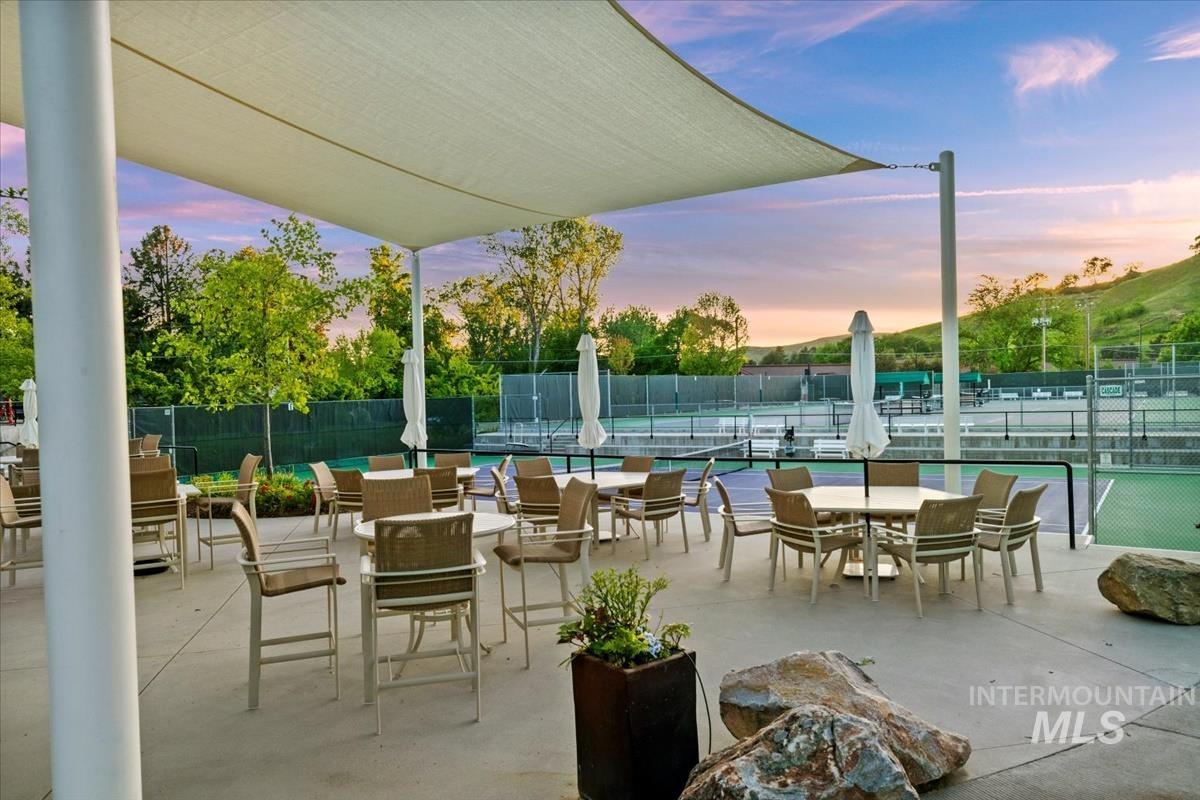 View of patio featuring outdoor dining area and a tennis court