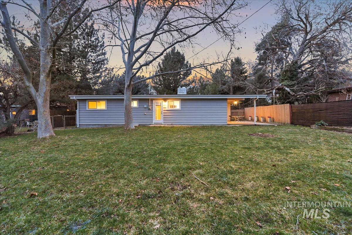 Back of house at dusk with a fenced backyard
