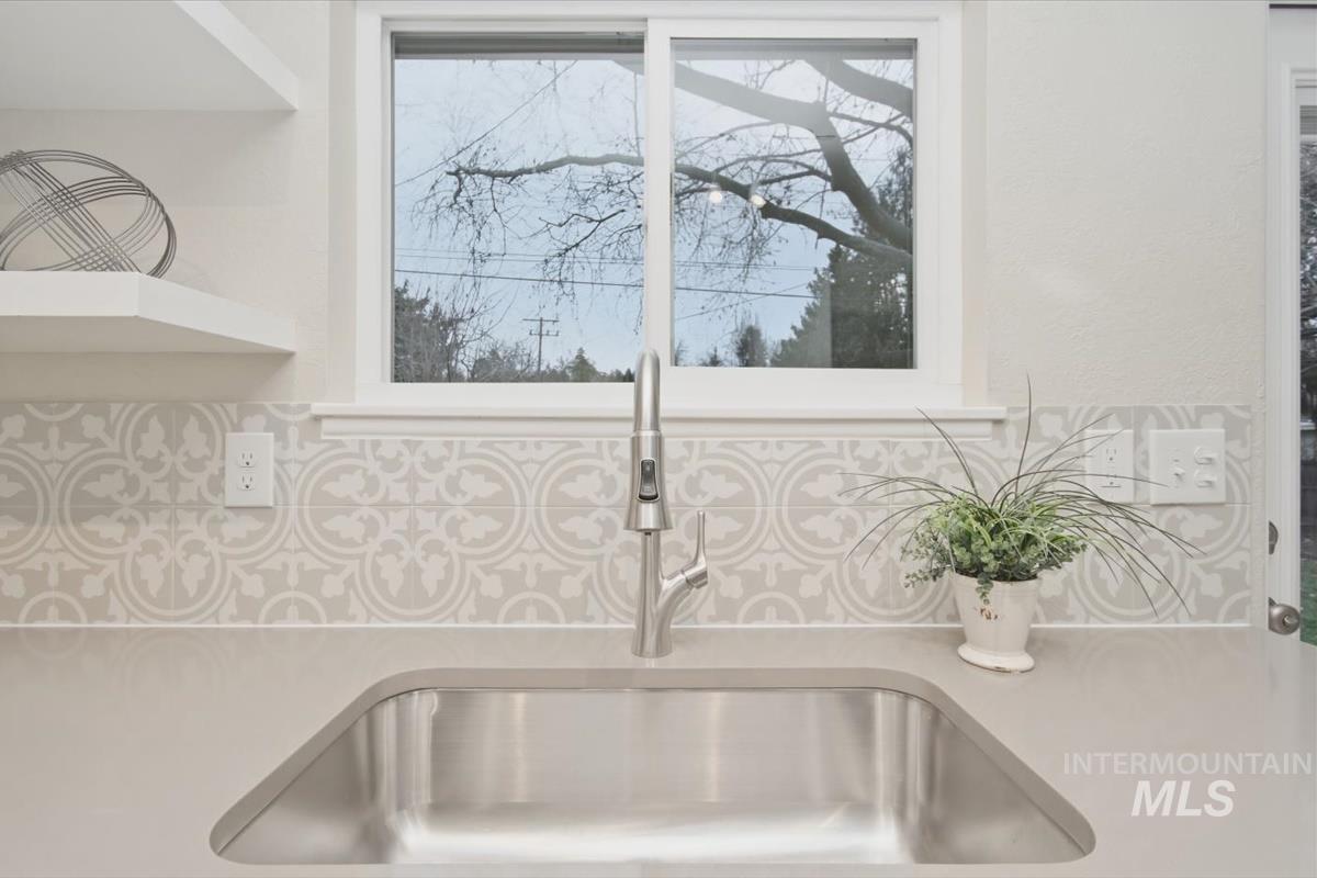 Kitchen view of open shelves and light stone countertops