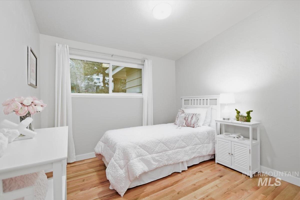 Bedroom featuring light wood finished floors and lofted ceiling