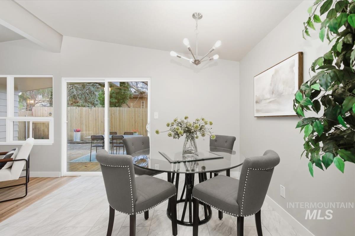 Dining area featuring hanging lights and vaulted ceiling with beams