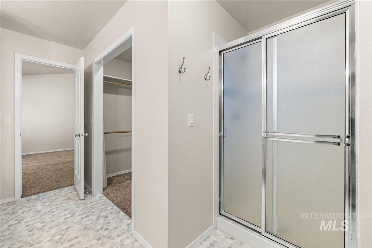 Bathroom featuring a stall shower and a spacious closet