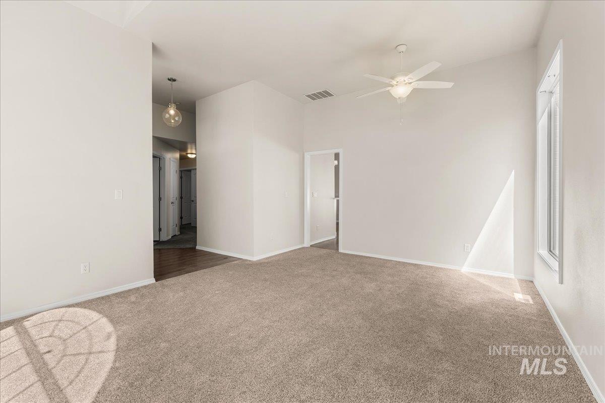 Empty room with carpet flooring and ceiling fan