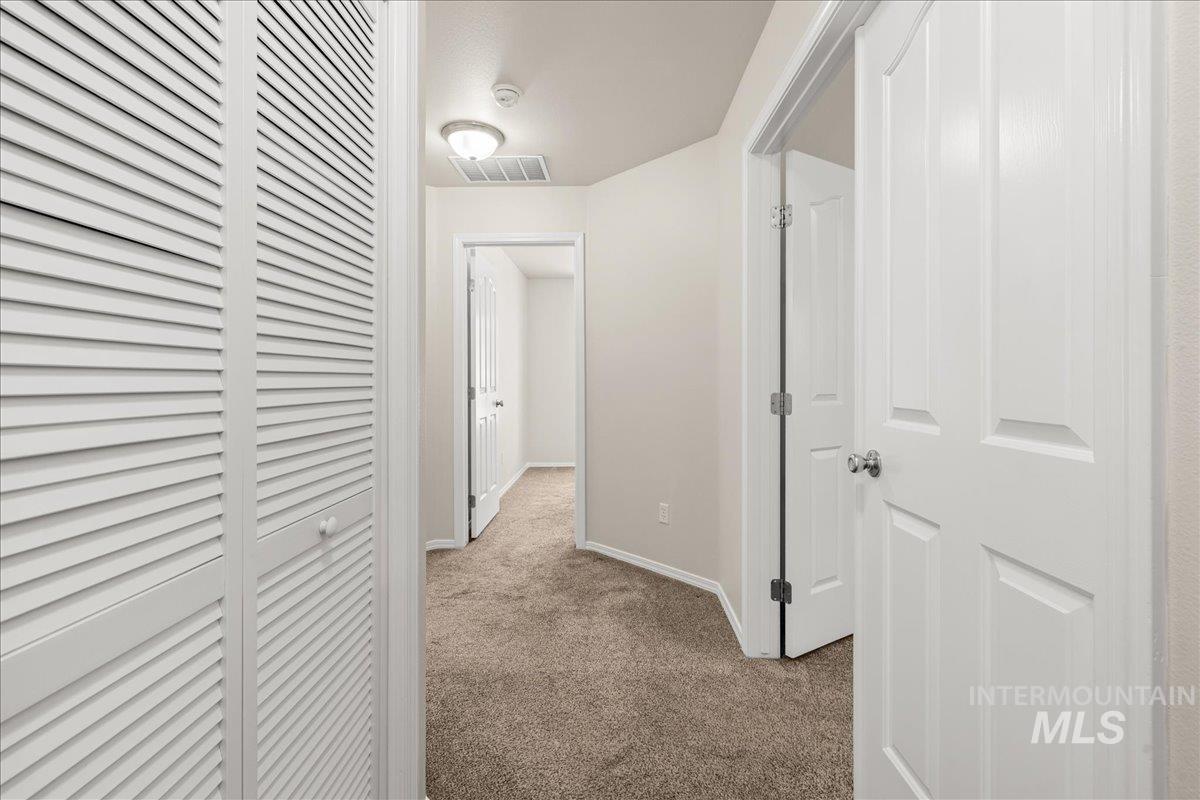 Hallway with carpet flooring and baseboards