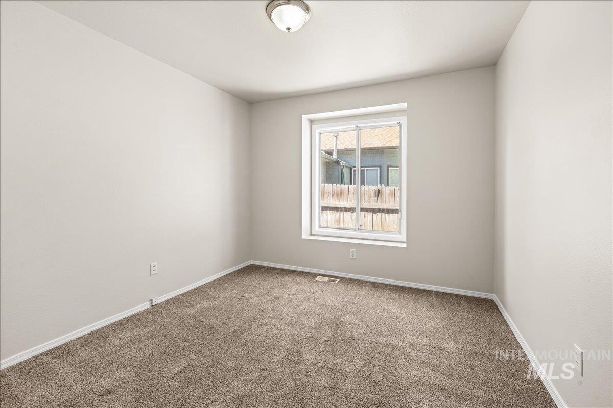 Carpeted empty room featuring baseboards