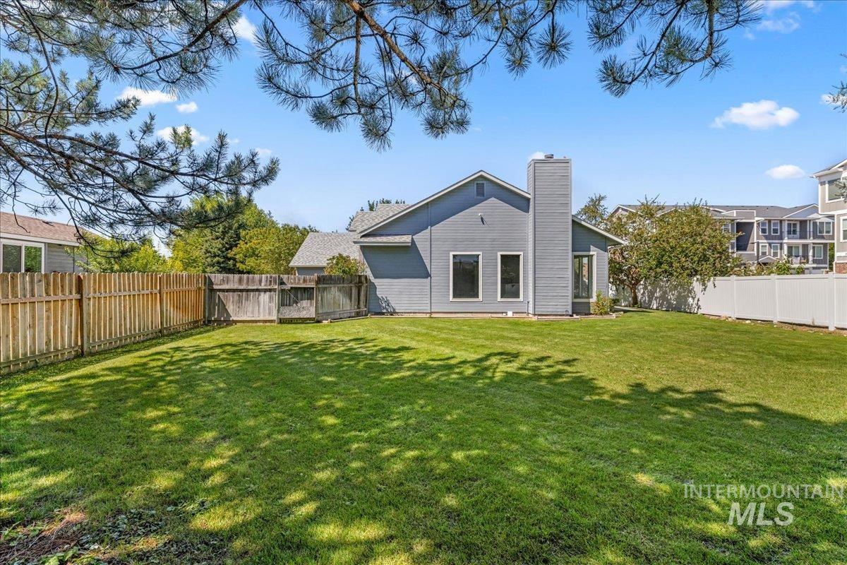 Back of property featuring a fenced backyard and a chimney