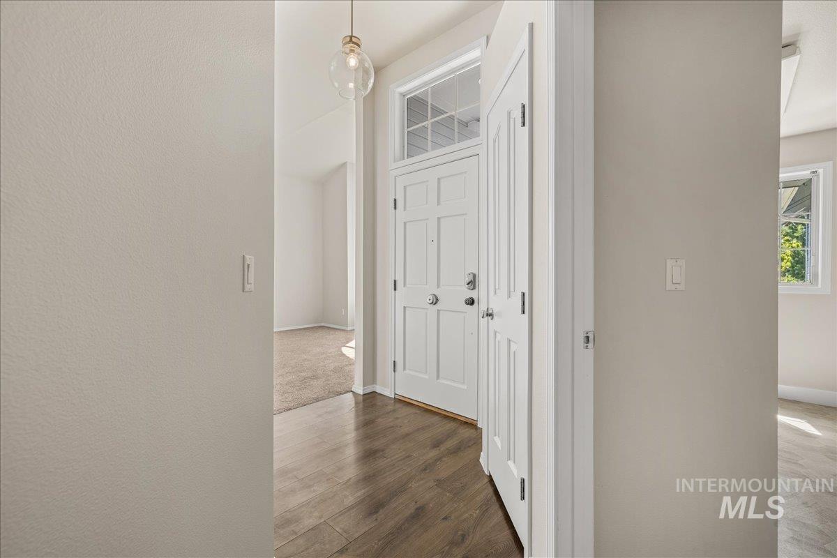 Corridor with dark wood-style flooring and baseboards