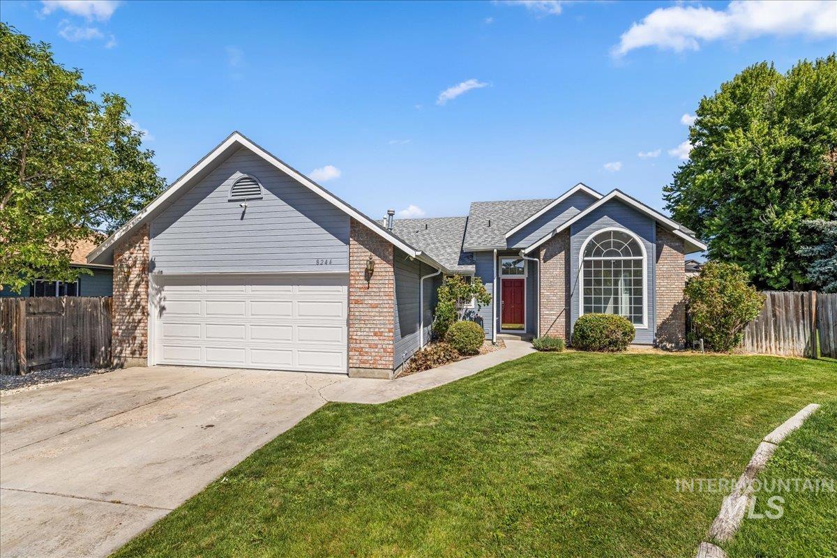 Single story home featuring brick siding, a garage, and concrete driveway