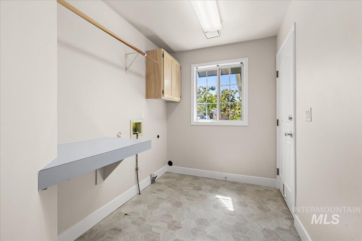 Laundry room with hookup for a washing machine, cabinet space, and gas dryer hookup