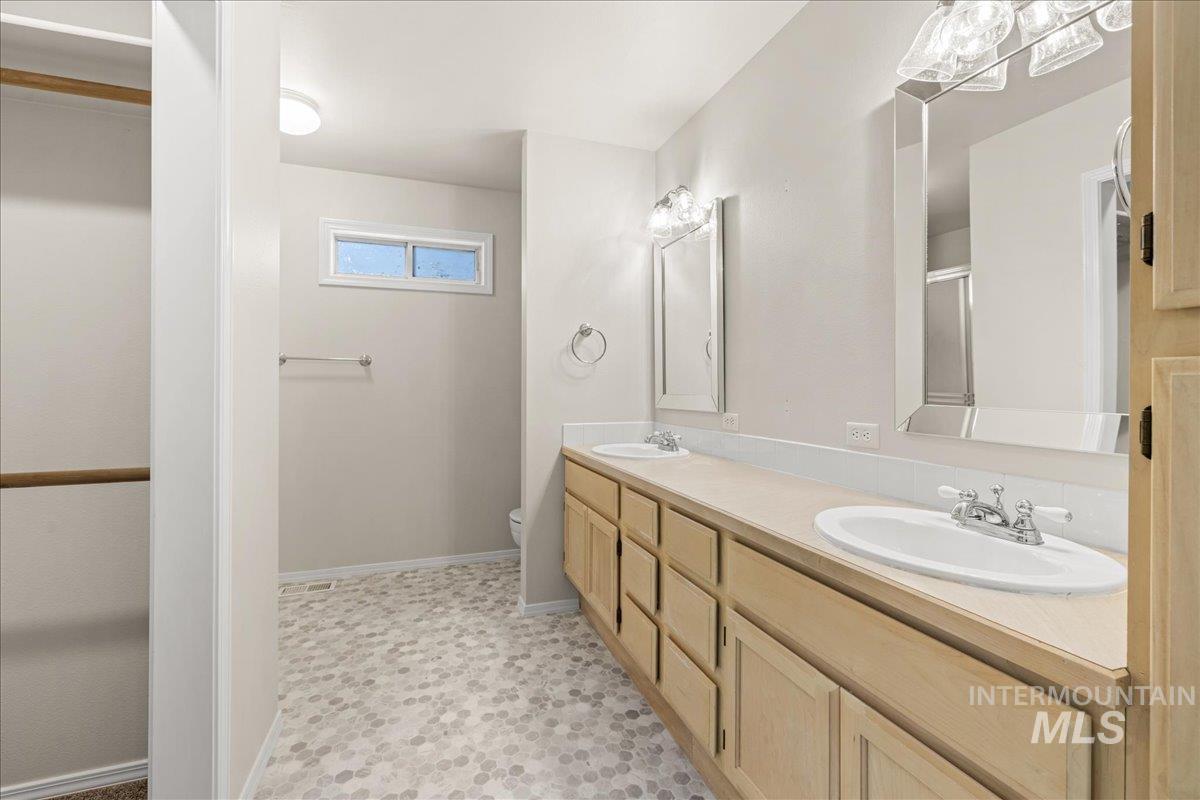Bathroom featuring double vanity and a shower stall