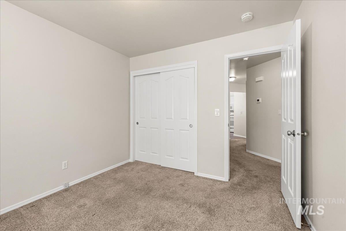 Unfurnished bedroom featuring carpet and a closet