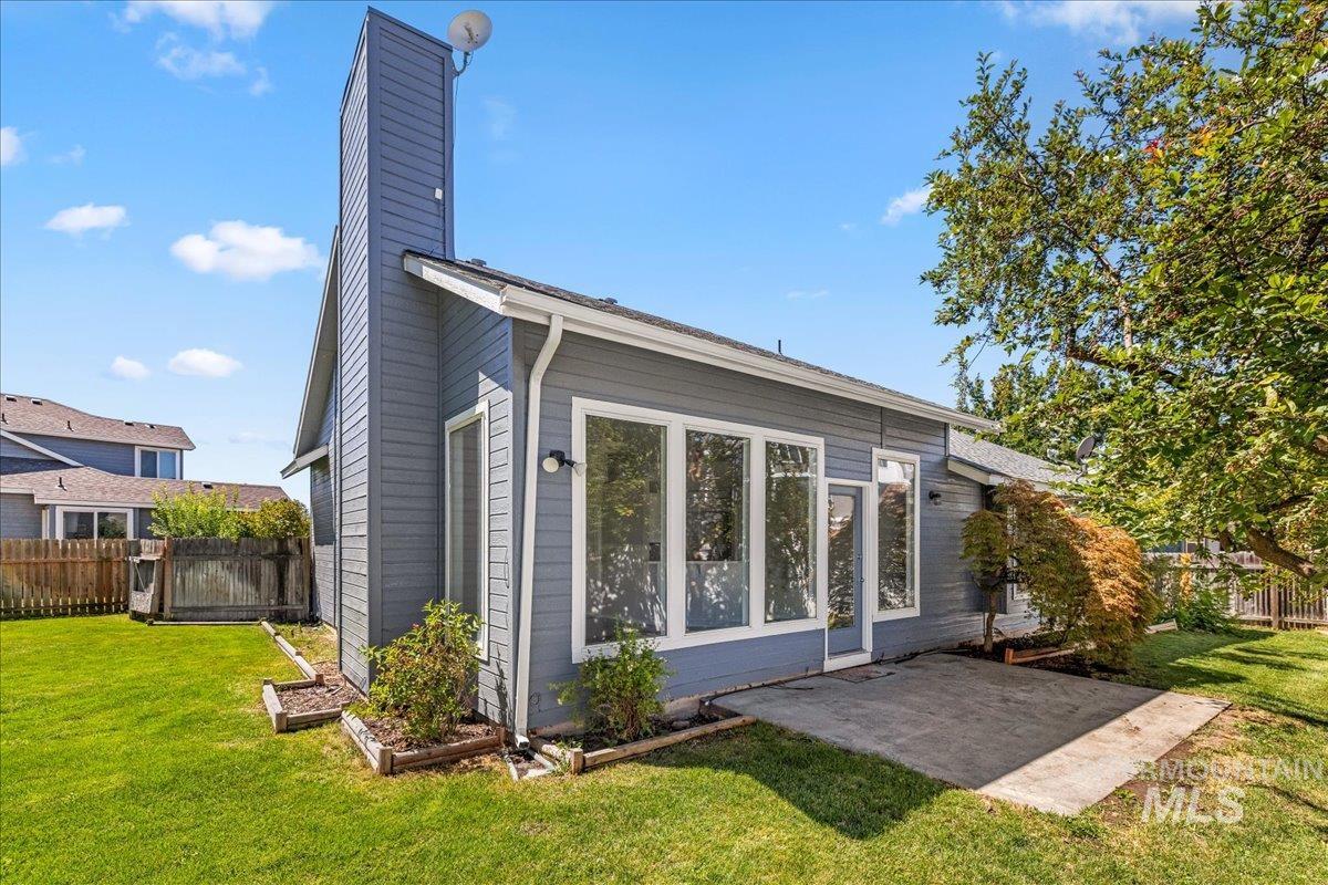 Rear view of property featuring a chimney and a patio area