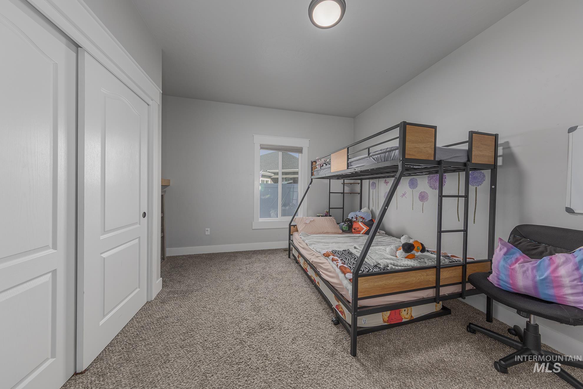 Bedroom with light colored carpet and a closet