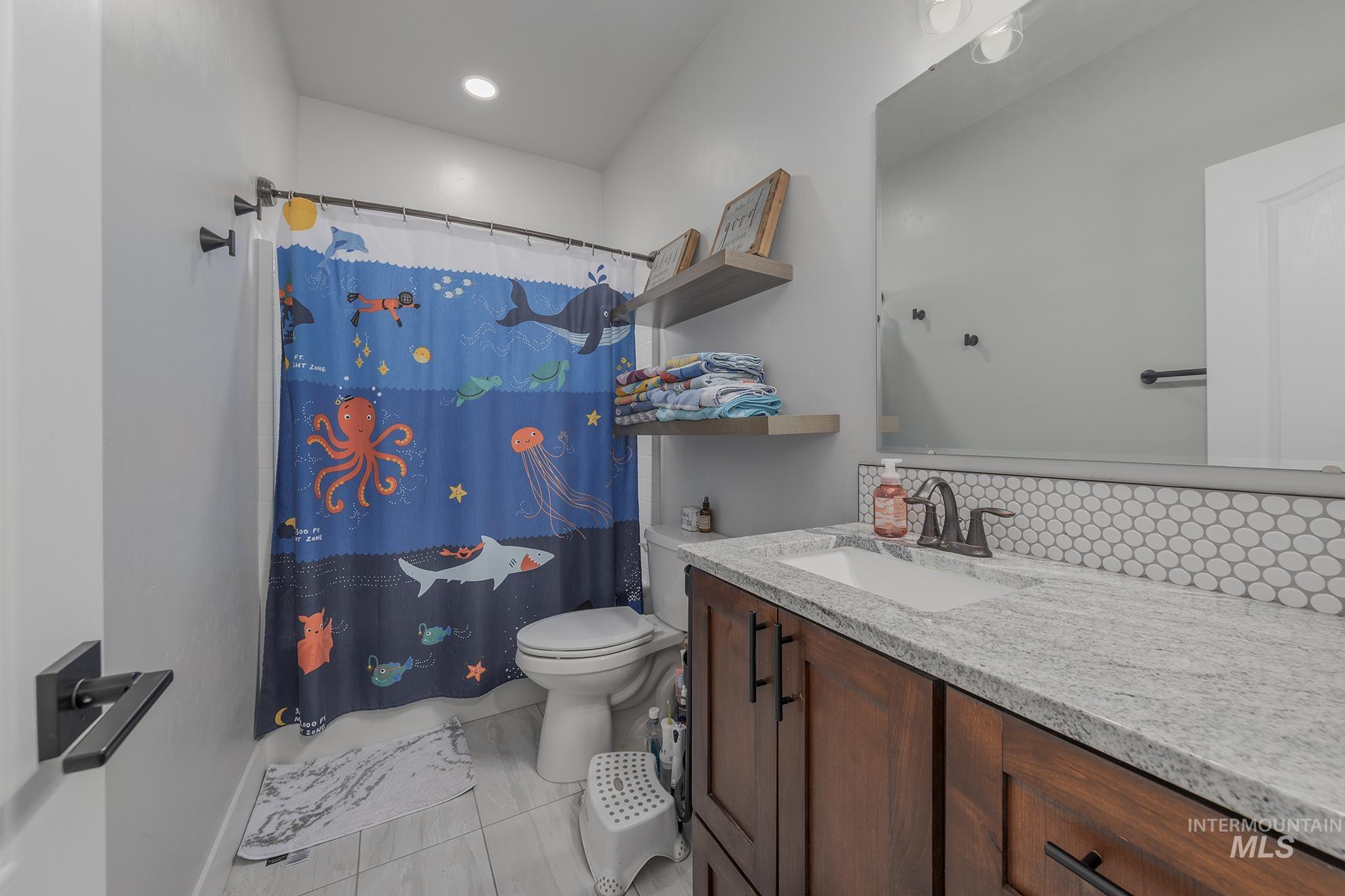Full bathroom featuring vanity and light tile patterned flooring