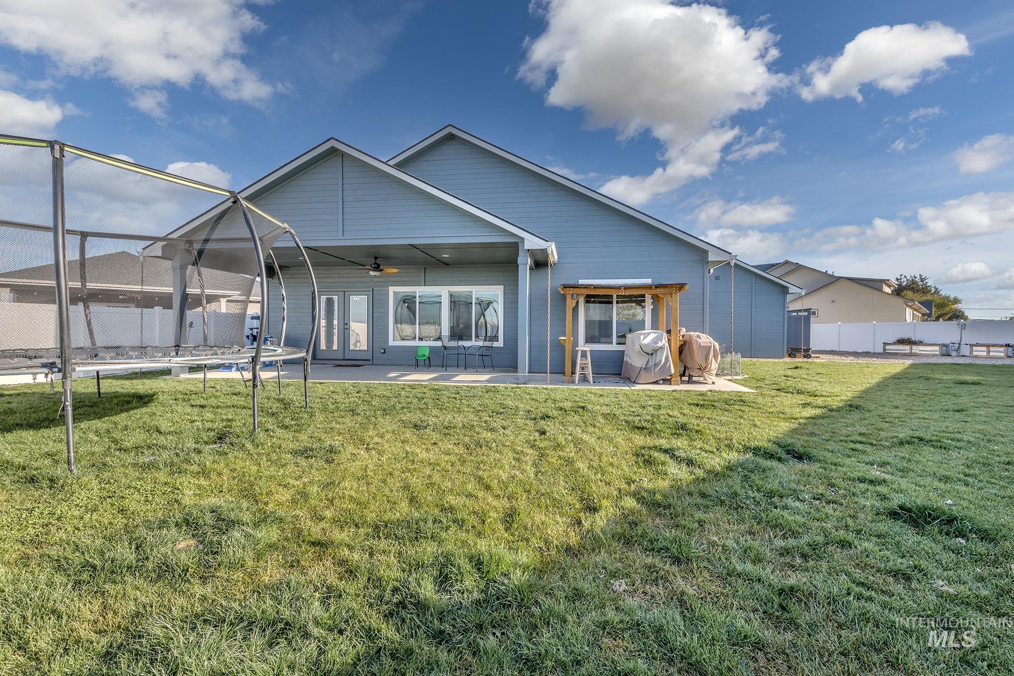 Rear view of house with a ceiling fan, a patio, and a fenced backyard