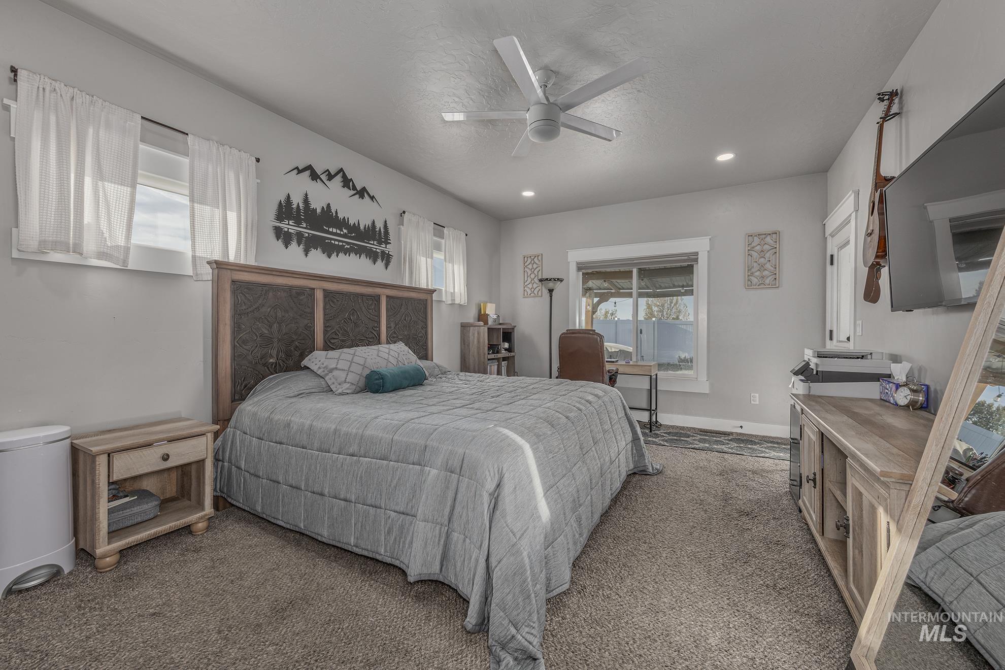 Carpeted bedroom with a ceiling fan, recessed lighting, and a textured ceiling