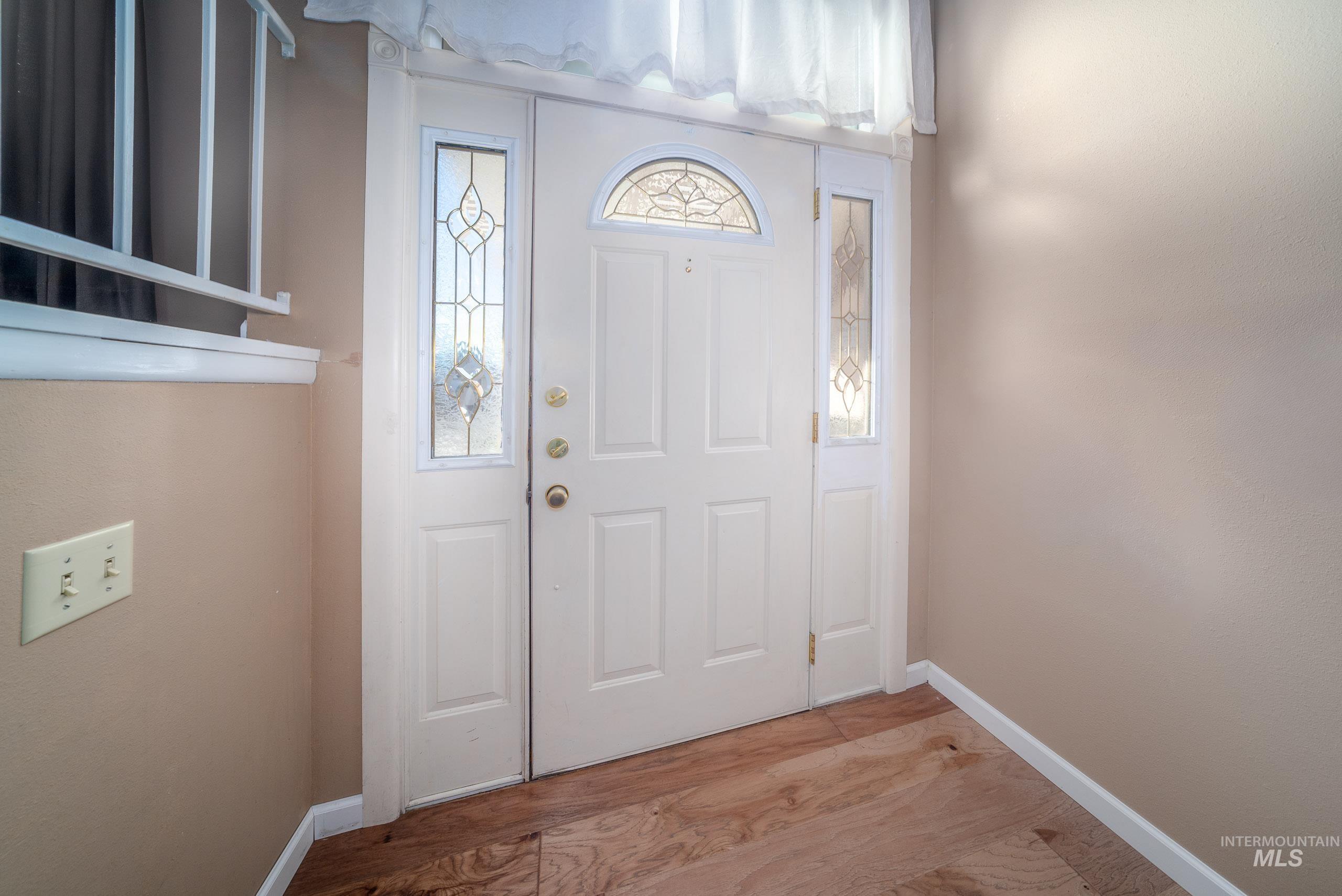 Foyer entrance featuring light wood-type flooring and baseboards