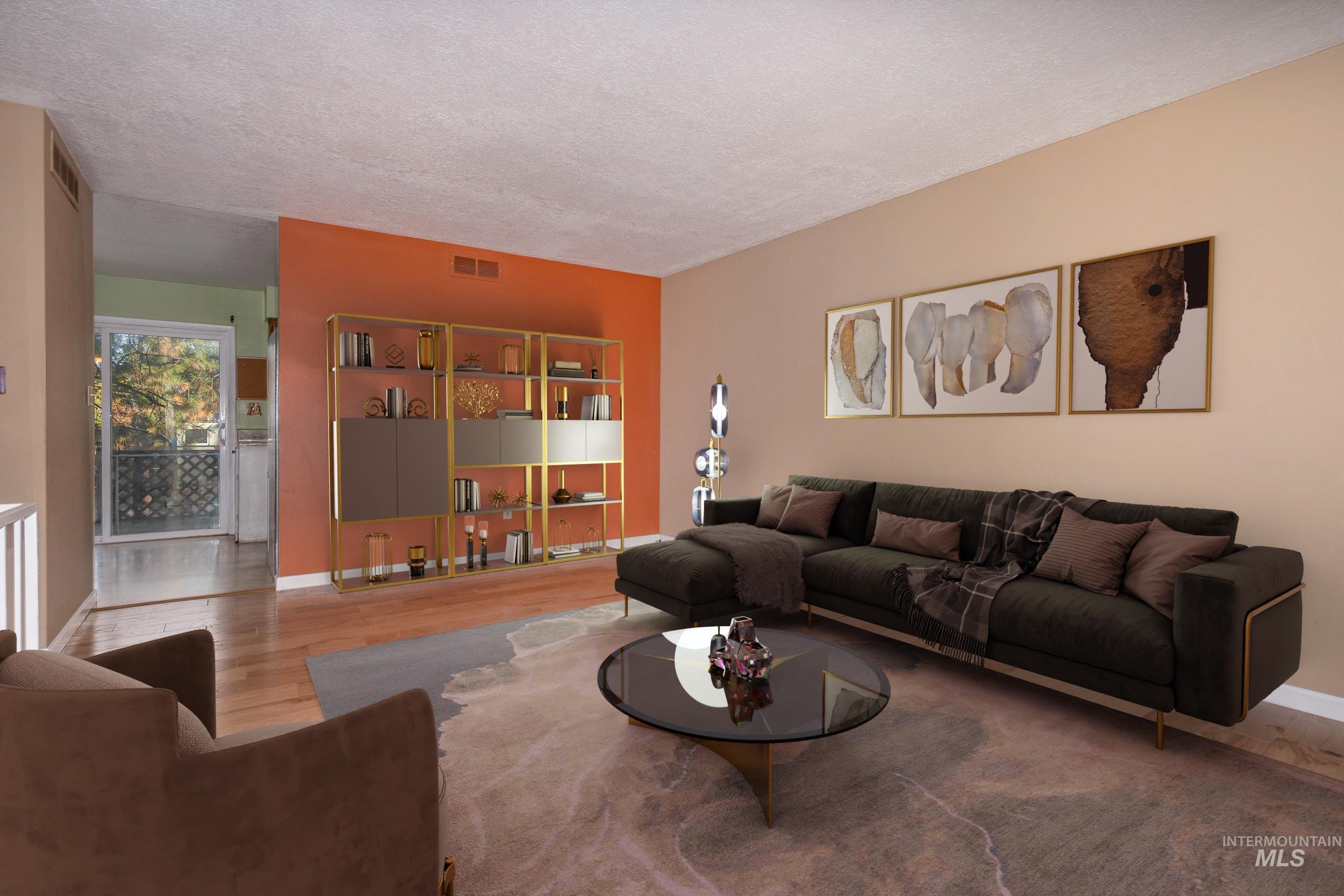 Living room with a textured ceiling and wood finished floors