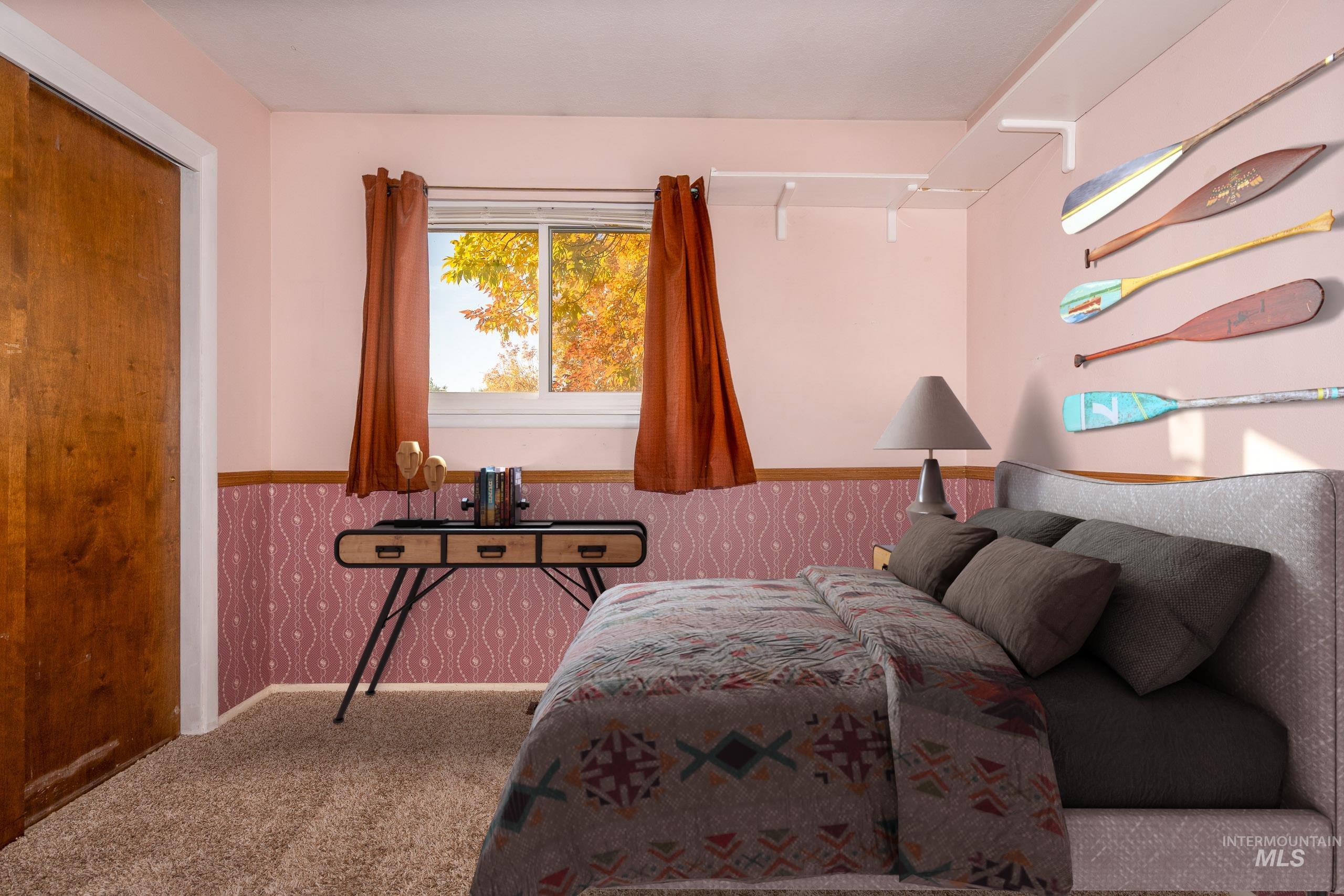 Carpeted bedroom featuring wallpapered walls and wainscoting