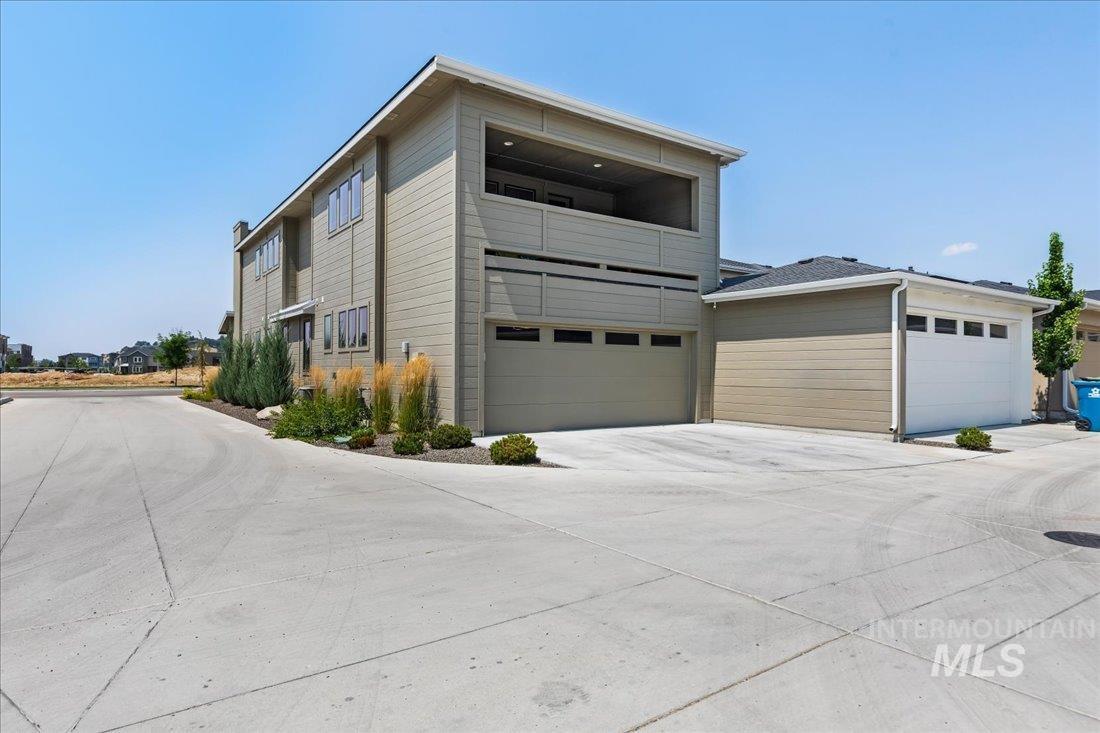 View of front facade with a balcony and concrete driveway