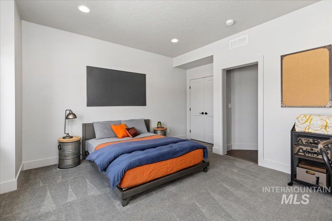 Carpeted bedroom featuring a textured ceiling and recessed lighting