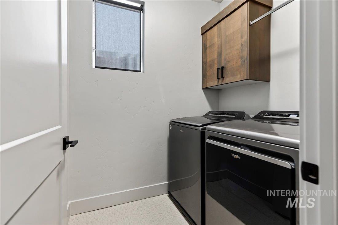 Laundry room featuring cabinet space and separate washer and dryer