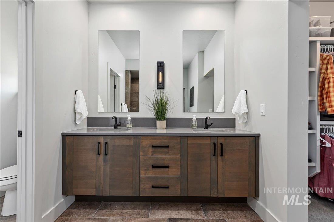 Full bathroom with double vanity and a spacious closet