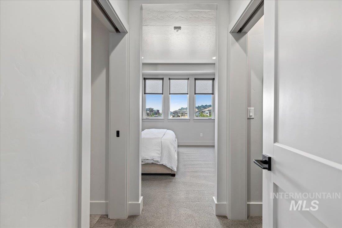 Corridor featuring baseboards and light carpet