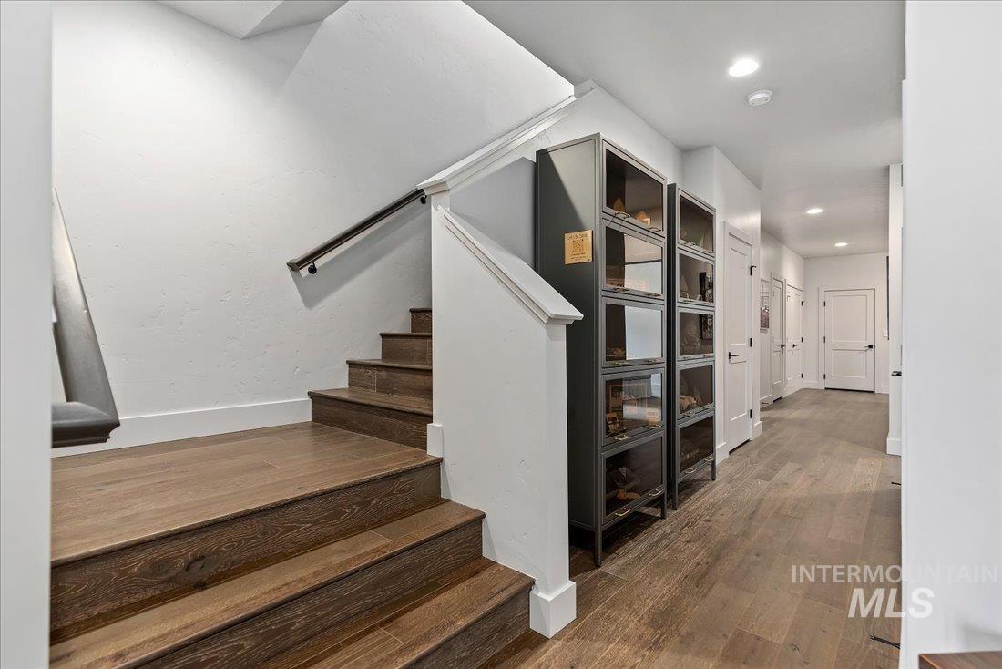 Staircase featuring hardwood / wood-style floors and recessed lighting