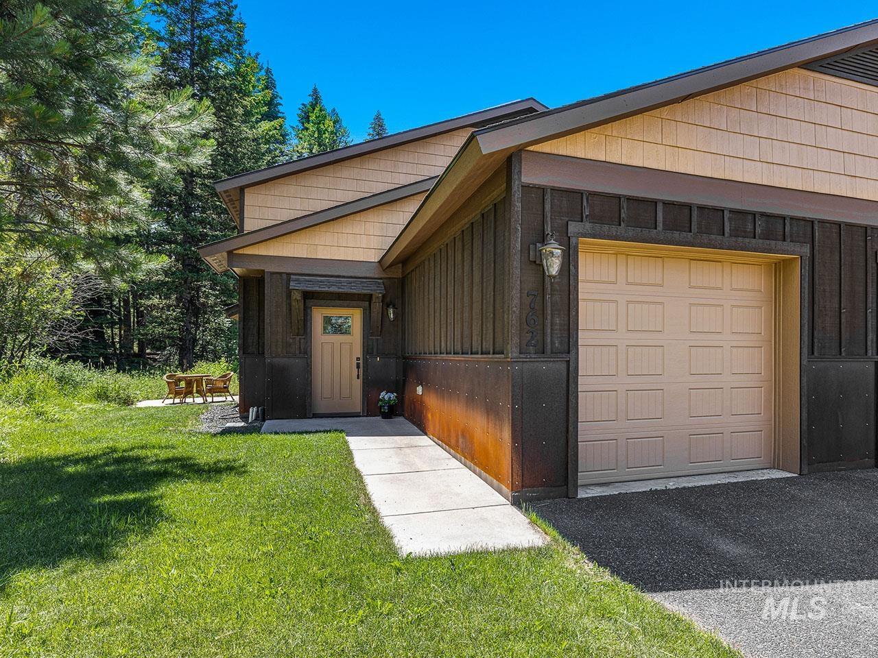View of front of property featuring a front yard and an attached garage