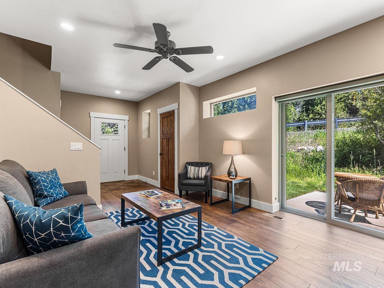 Living room featuring wood-type flooring, a ceiling fan, and recessed lighting