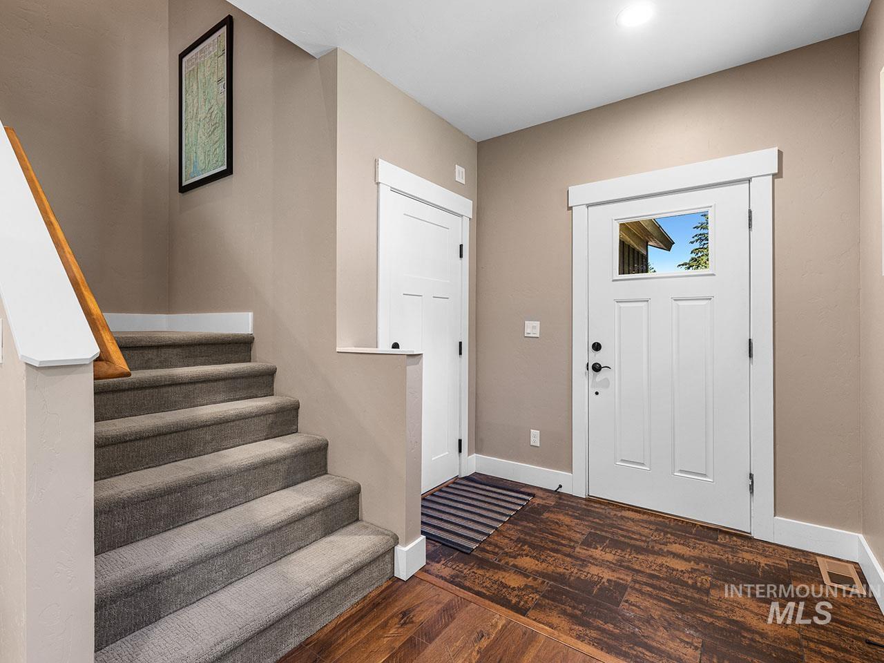 Entryway with wood-type flooring, stairs, and recessed lighting