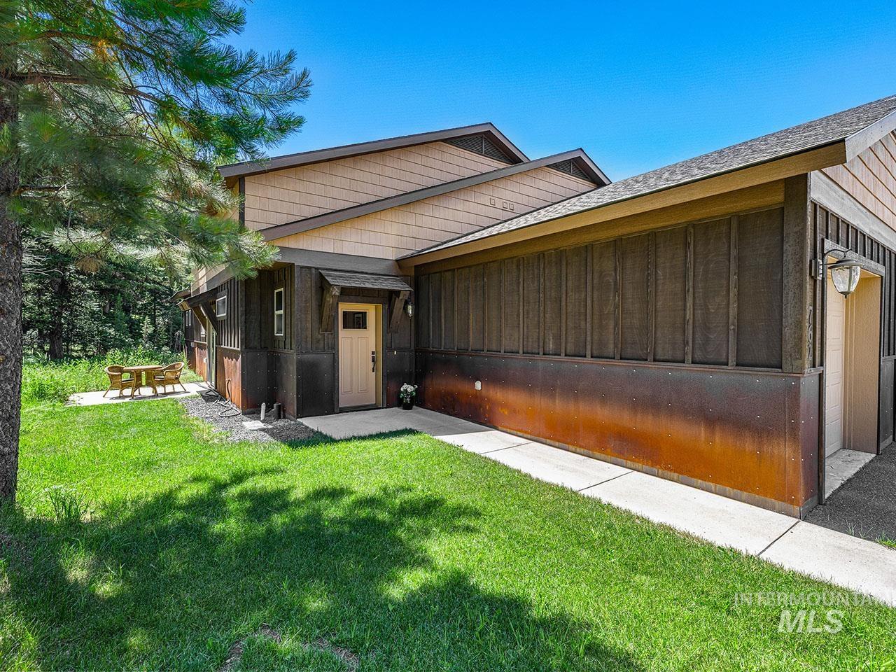 View of front of house with a front lawn, board and batten siding, and a shingled roof