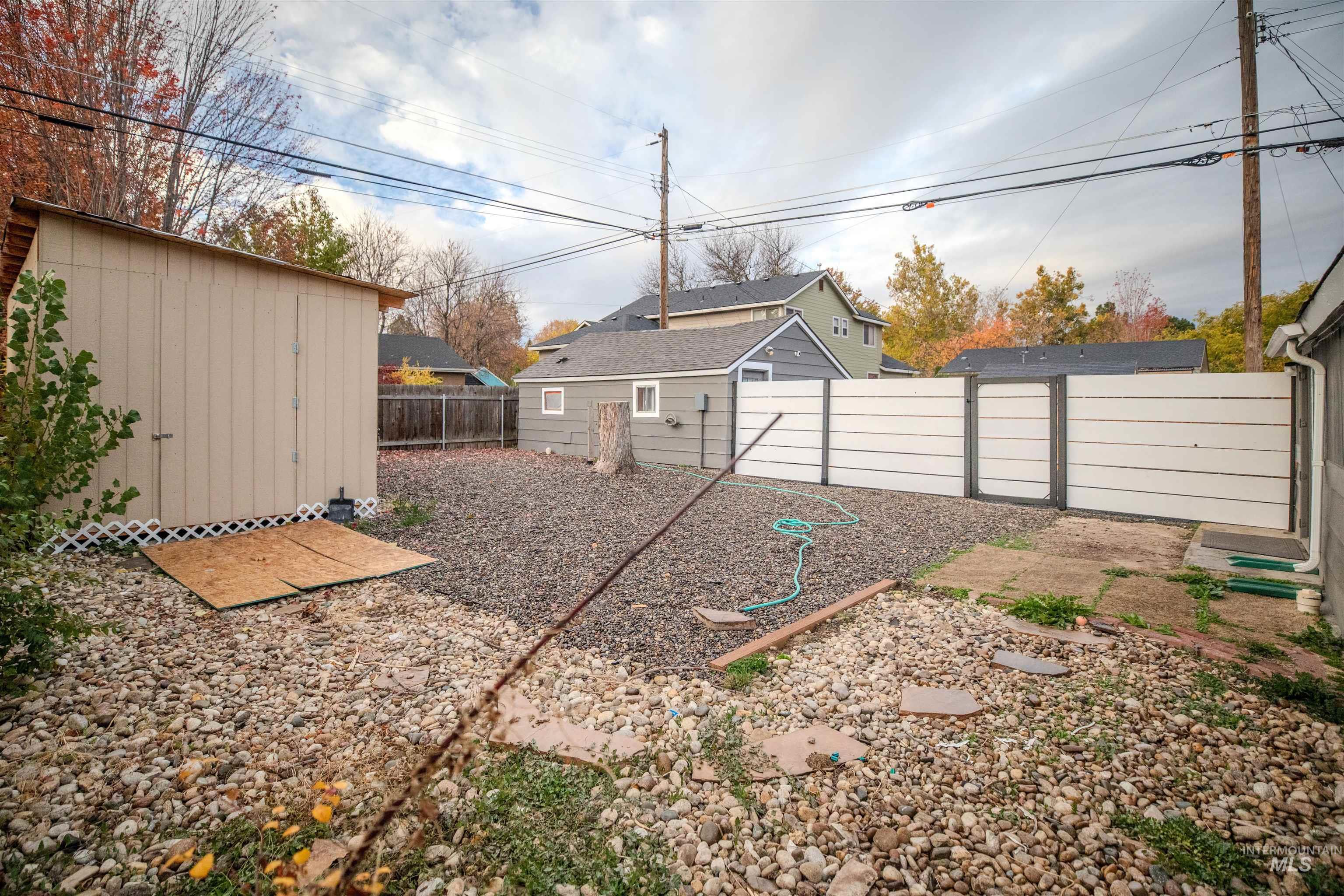 Fenced backyard featuring a storage shed