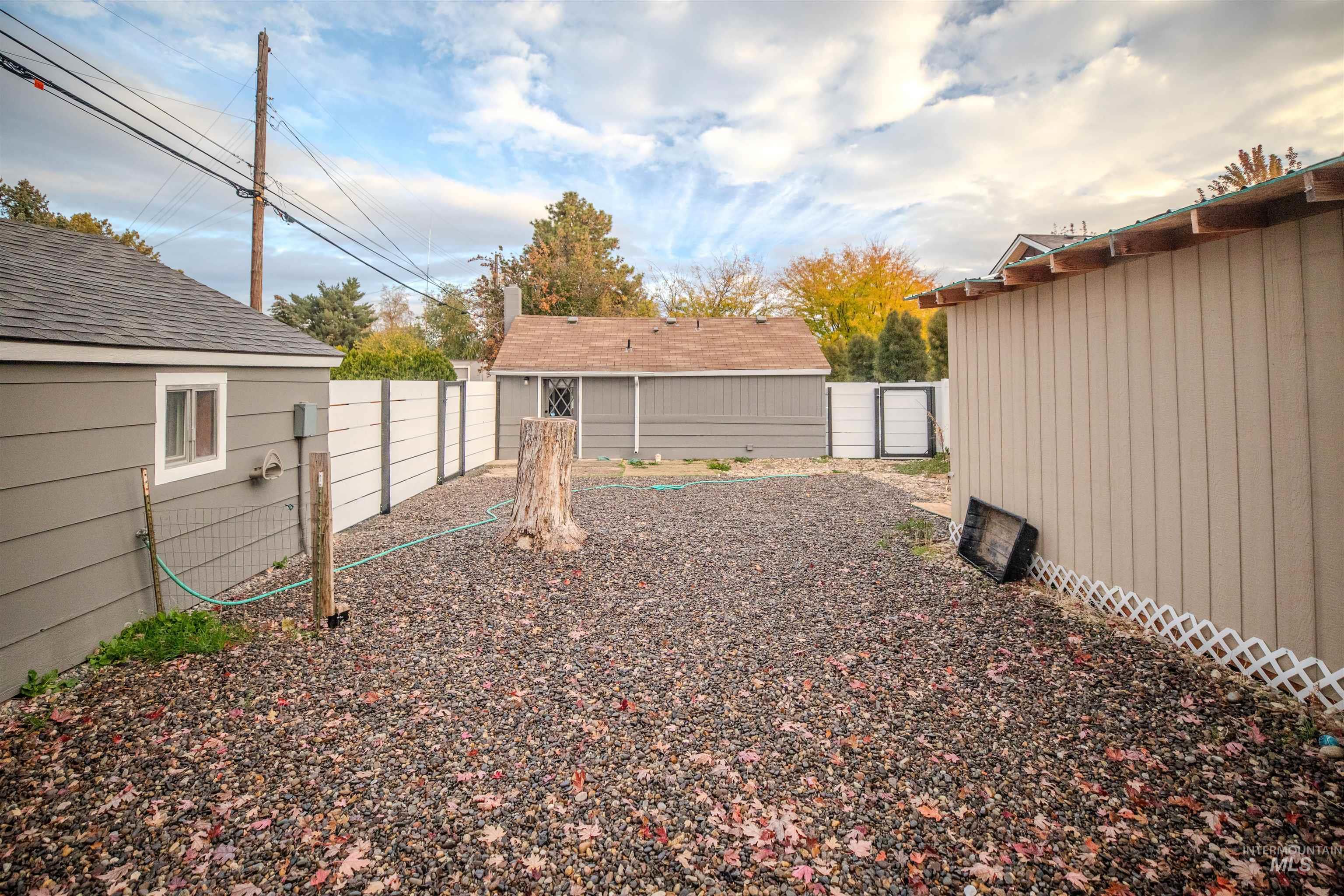 Fenced backyard featuring storage shed.
