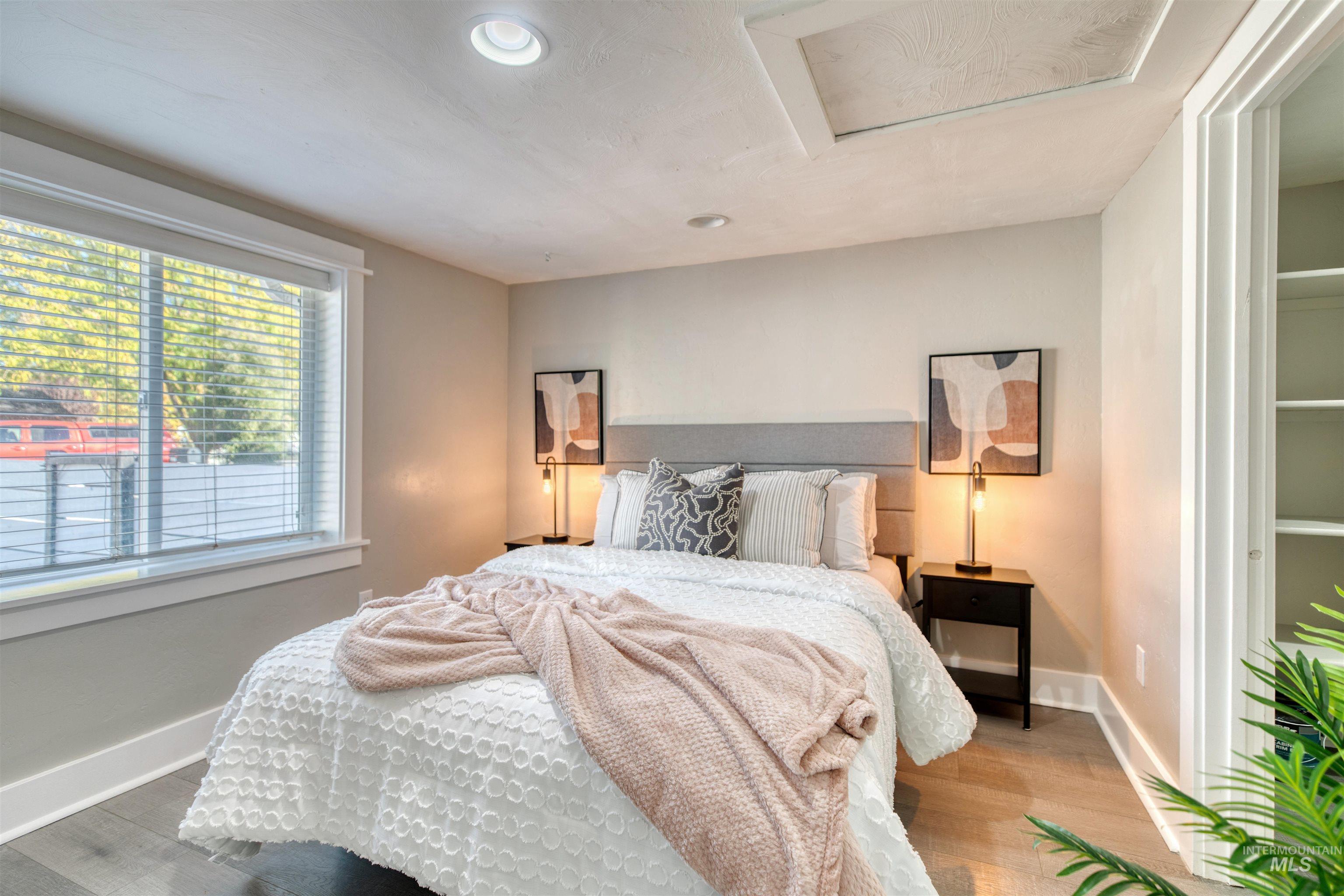 Bedroom with attic access, recessed lighting, and wood finished floors