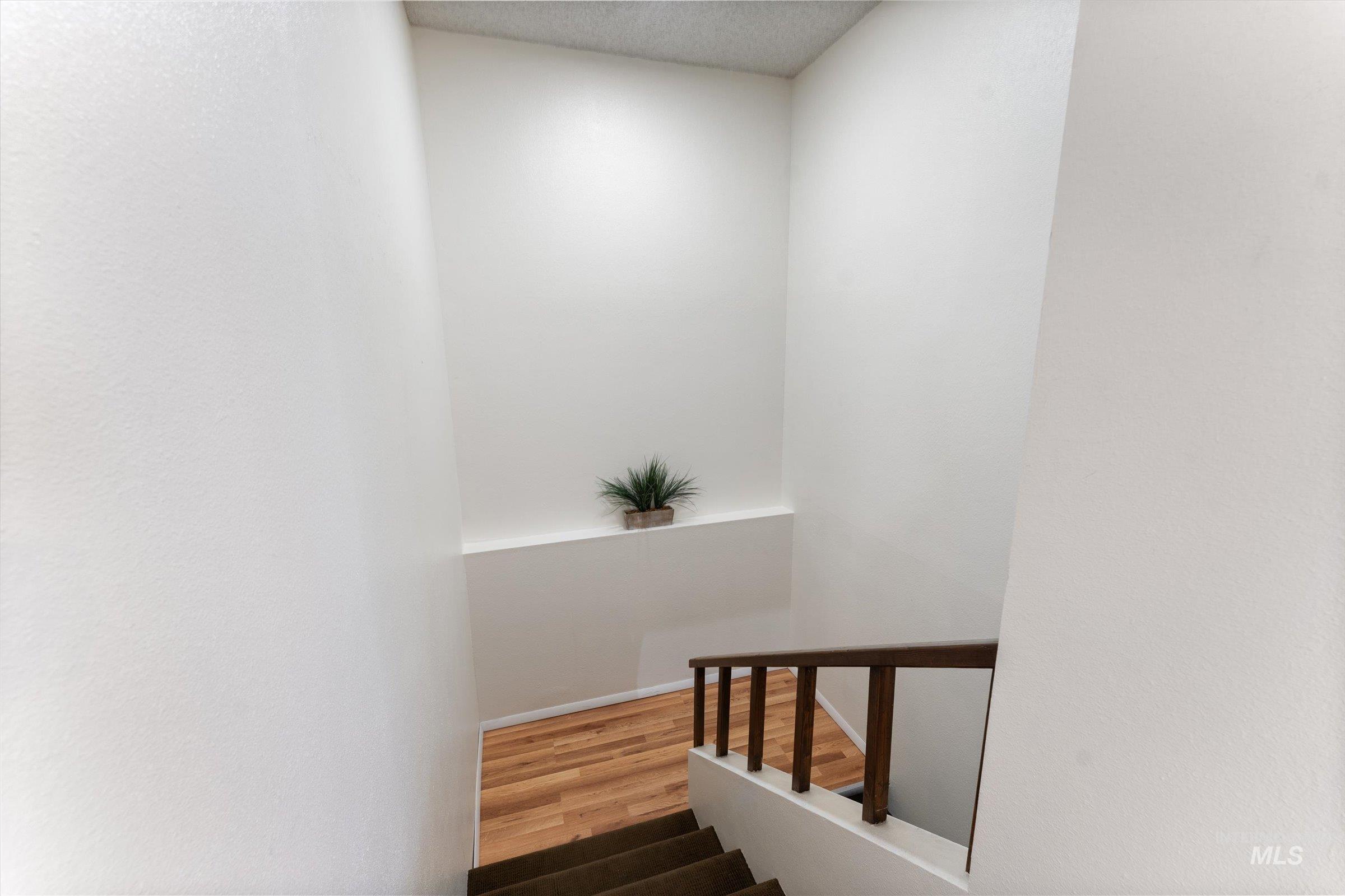 Staircase featuring wood finished floors and a textured ceiling