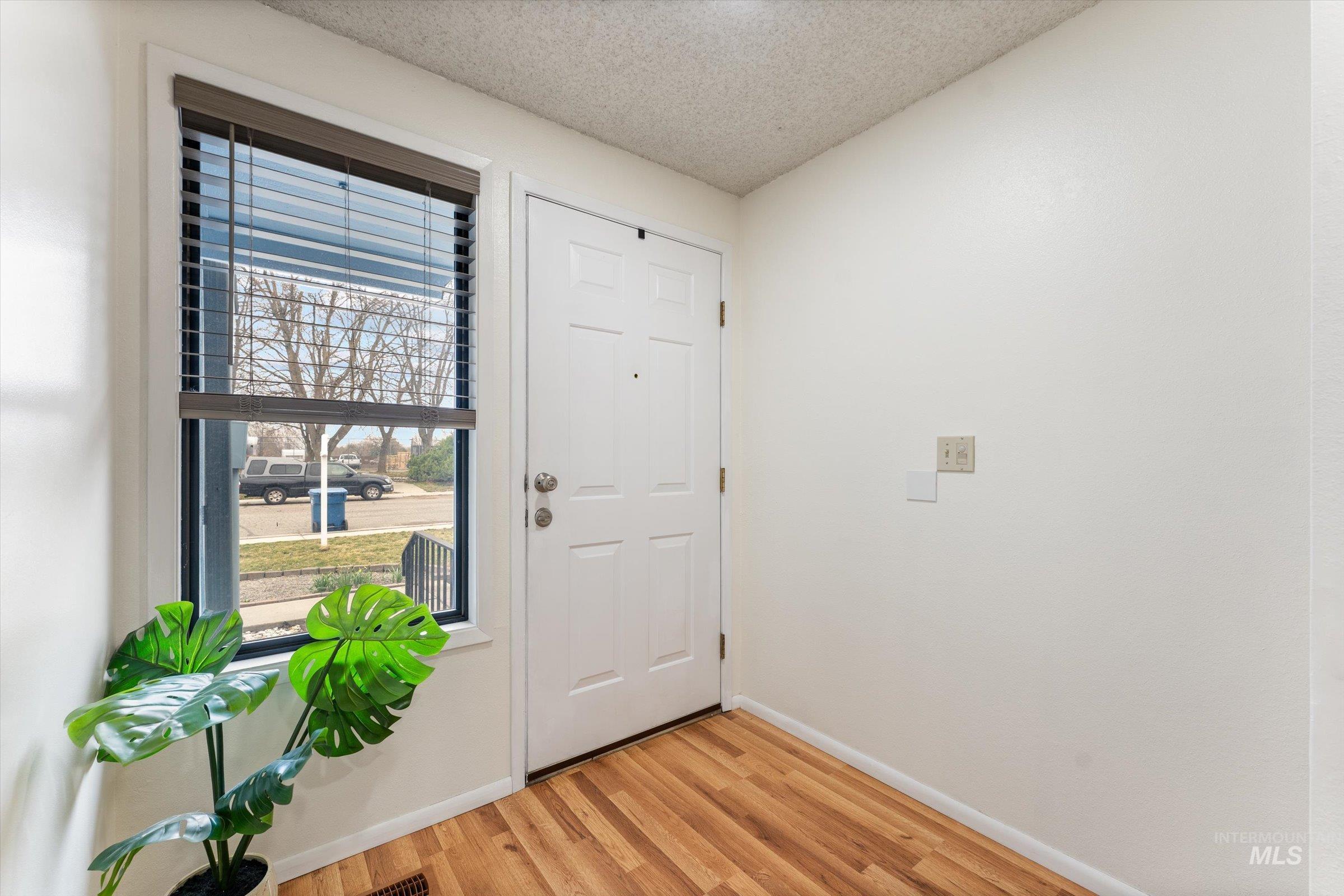 Entryway featuring a textured ceiling and light wood-type flooring