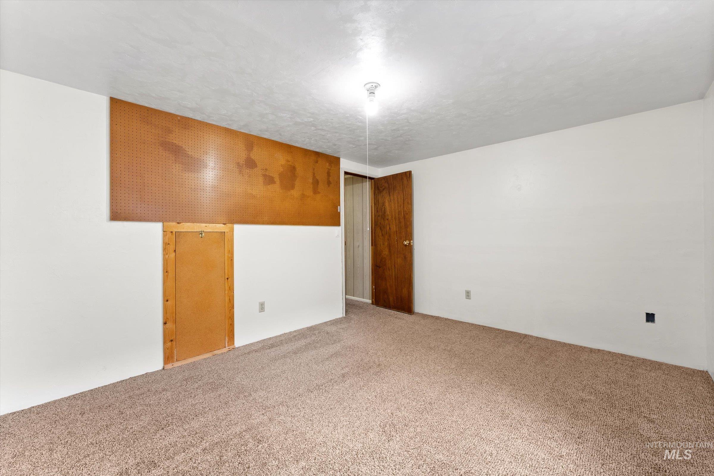 Carpeted empty room with a textured ceiling