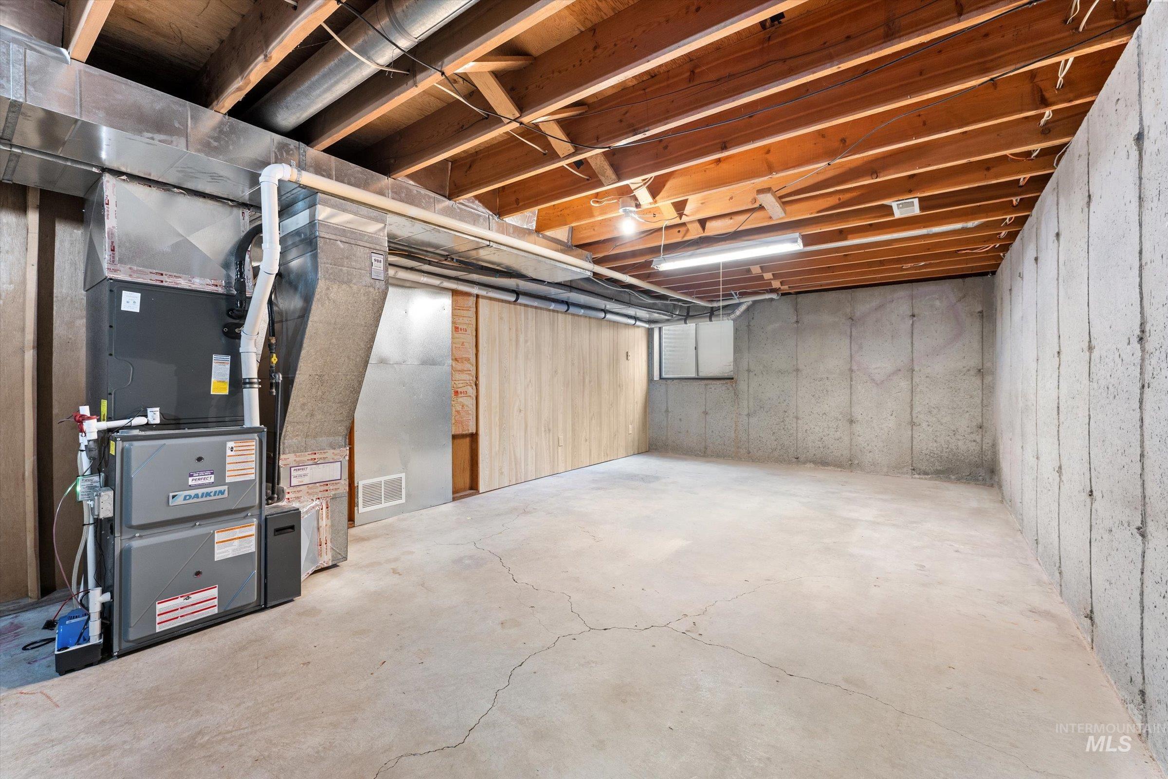 Unfinished basement featuring heating unit