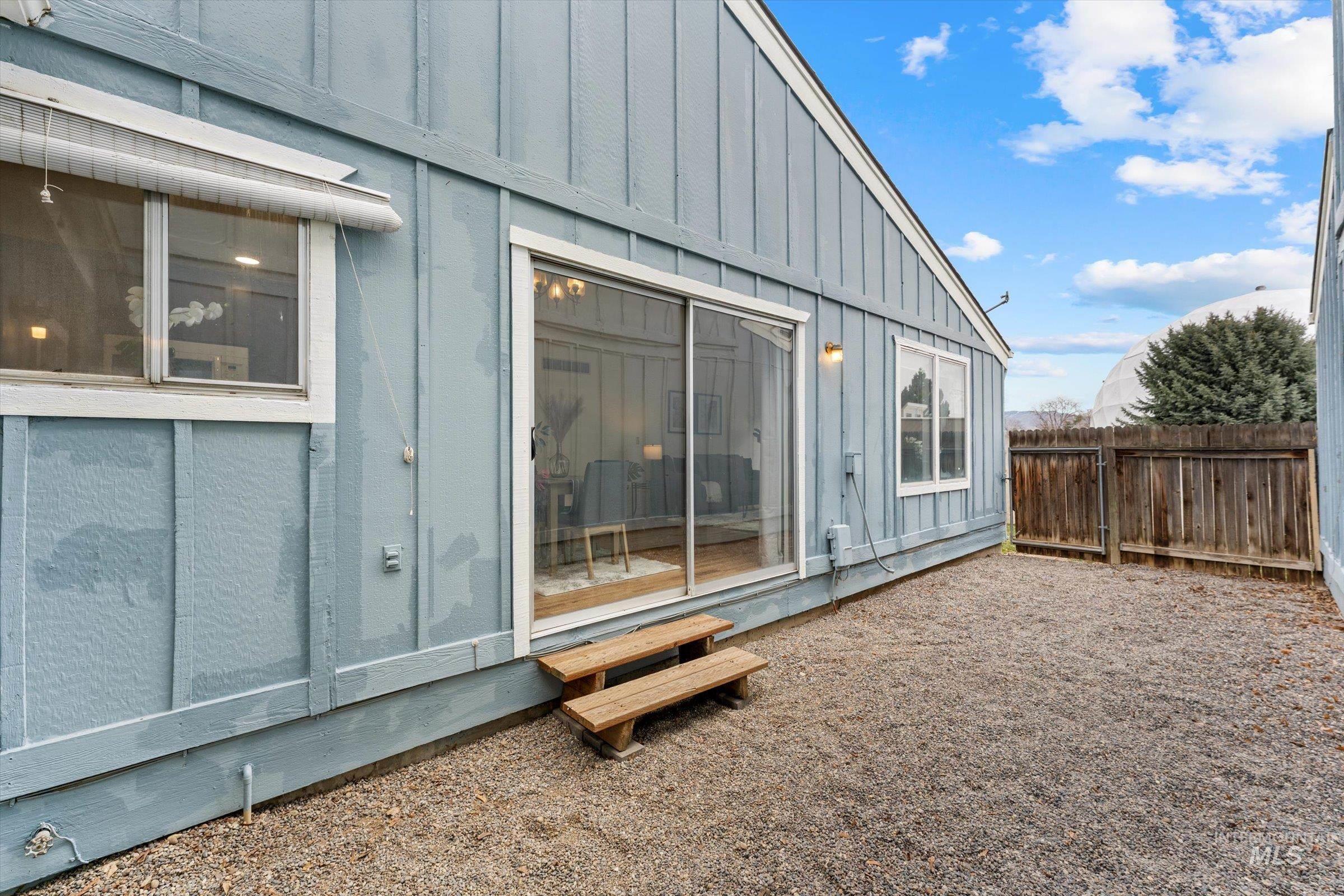 Rear view of property with board and batten siding and a fenced backyard