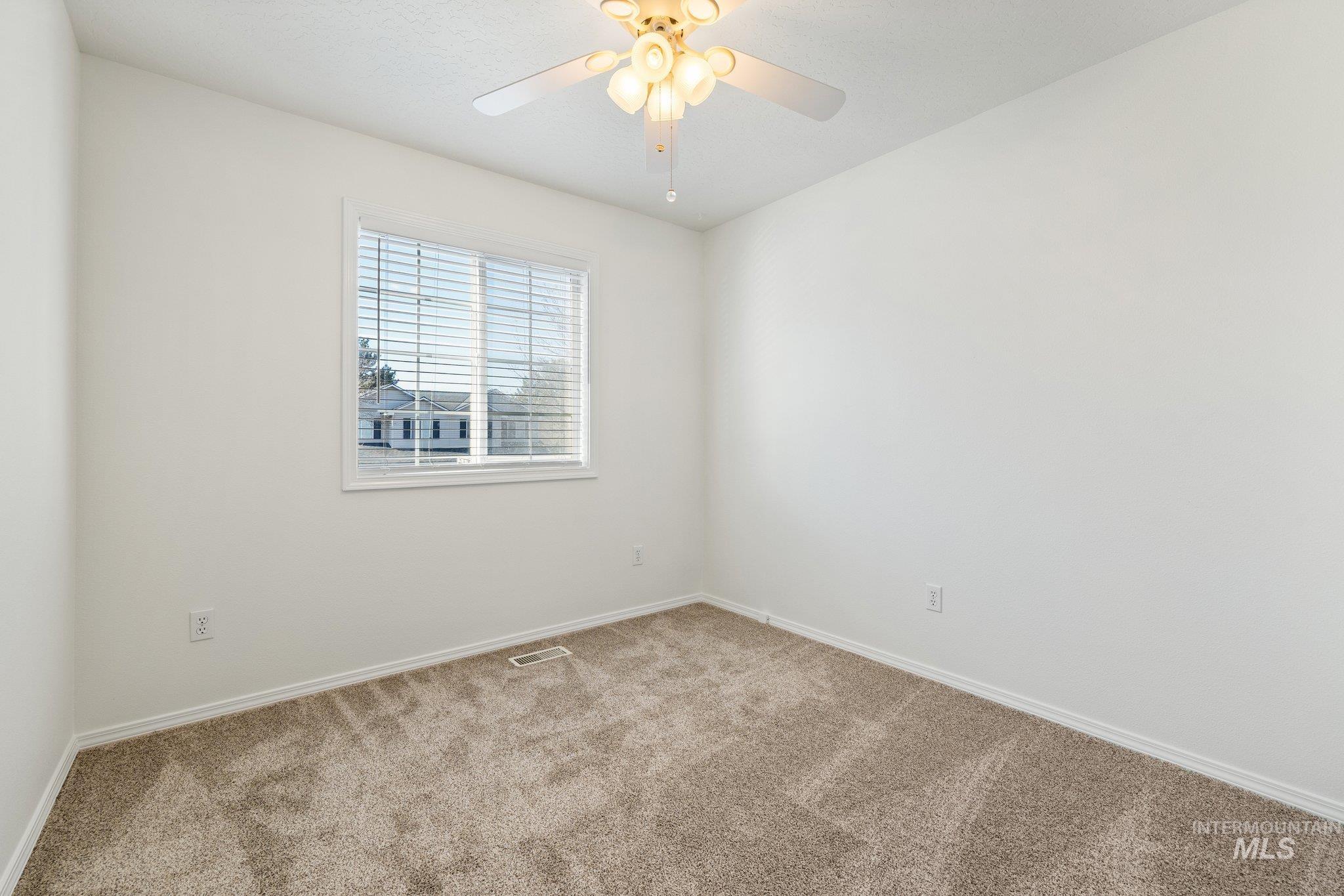 Unfurnished room featuring carpet and ceiling fan