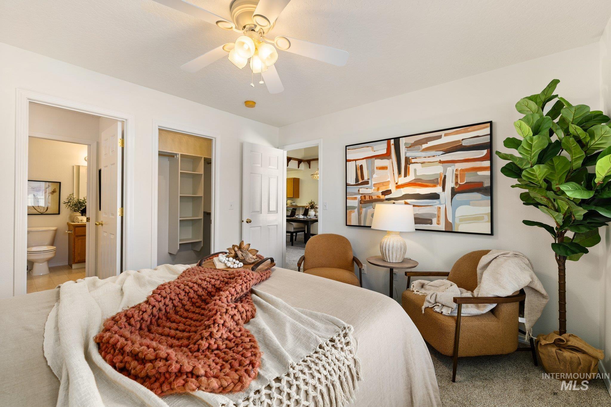 Bedroom featuring a walk in closet, a ceiling fan, connected bathroom, and carpet floors