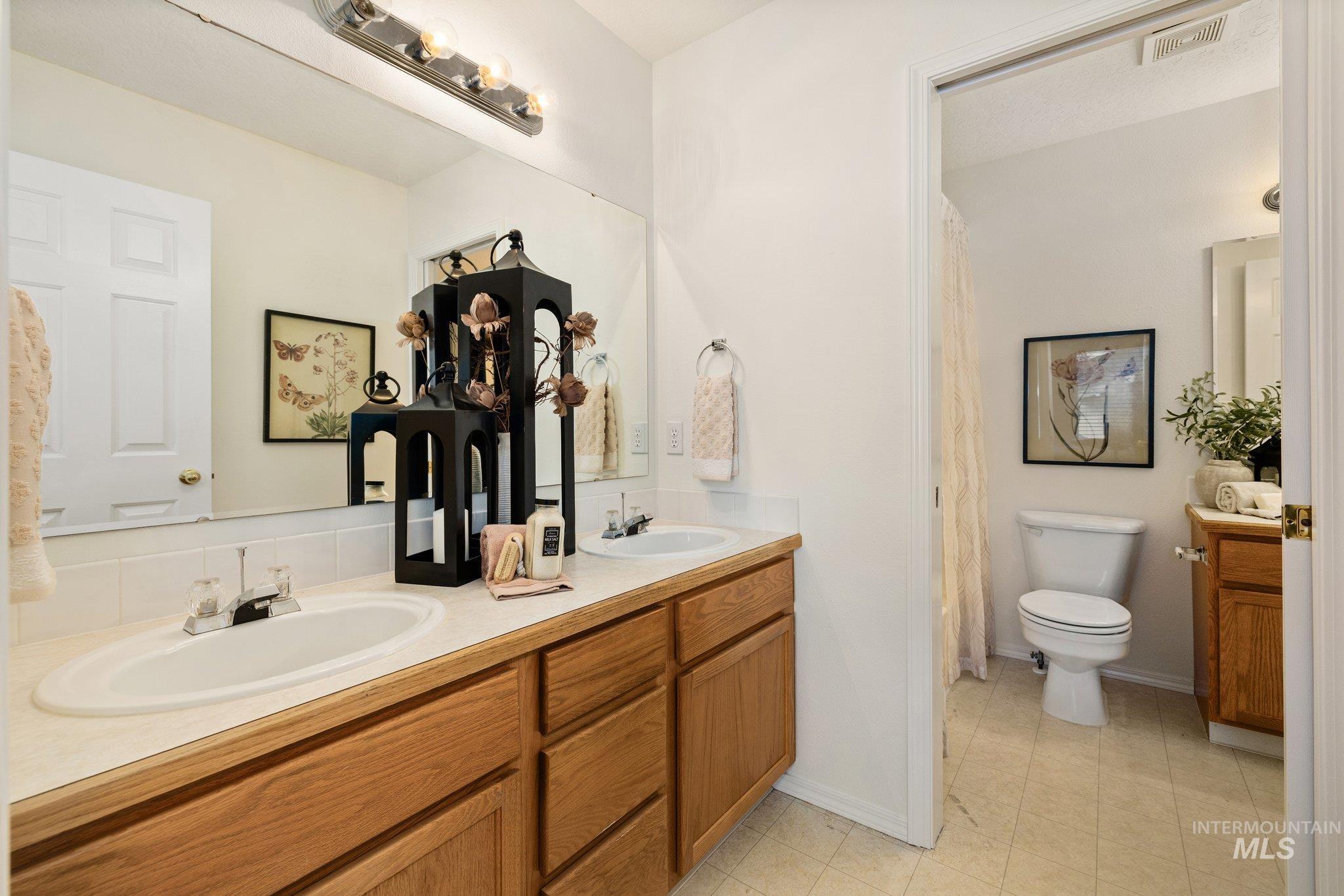 Full bath featuring double vanity and curtained shower