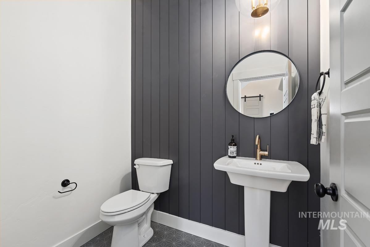 Bathroom with tile patterned floors and wood walls